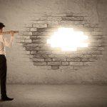 Man With A Hammer Looking At A Hole In The Wall